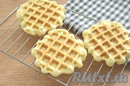 Затем перекладываем вафельку на решётку и оставляем остывать. Одну за другой (всего у меня получилось 7 штук) выпекаем все вафли, смазывая по мере необходимости панели вафельницы маслом.
