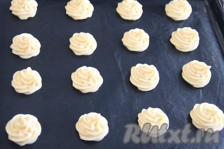 Переложить заварное тесто в кулинарный мешок и отсадить в виде профитролей на расстоянии друг от друга на противень, заранее застеленный ковриком (или пергаментом) для выпечки. У меня получилось 16 заготовок профитролей. Если нет кулинарного мешка, можно отсадить профитроли с помощью столовой ложки.