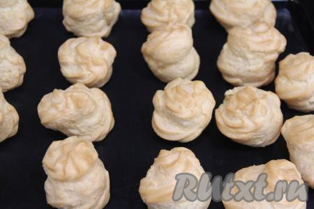 Поставить противень в разогретую до 220 градусов духовку. Выпекать профитроли 10 минут, затем убавить температуру до 180 градусов и выпекать ещё 15 минут. Профитроли в процессе выпечки хорошо увеличатся в размерах и подрумянятся. Духовку в процессе выпечки открывать нельзя! Готовые профитроли достать из духовки, дать им полностью остыть.