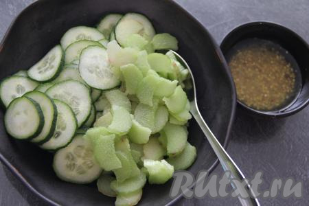 В салатник с огурцами выложить ревень. Для приготовления заправки для салата в небольшой ёмкости соединить масло, горчицу, лимонный сок и соль, тщательно перемешать. Влить заправку к ревеню и огурцам, хорошо перемешать.