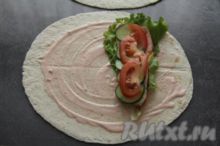 Затем поверх мяса выложить несколько кружочков огурца и несколько долек помидора, можно немного присолить.