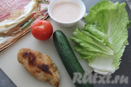 Куриное филе переложить на разделочную доску, дать немного остыть. Огурец, помидор и листья салата вымыть. Приготовить соус, для этого в небольшой ёмкости соединить сметану, майонез, паприку, хмели-сунели и чеснок, пропущенный через пресс, перемешать.