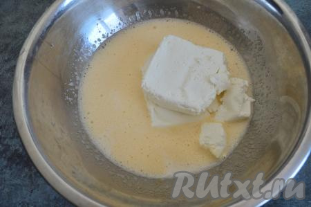 В получившуюся смесь яиц и сахара добавить творог, влить молоко, перемешать с помощью вилки или ложки до однородности, тщательно разминая творог.