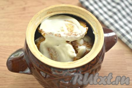 Выкладываем ещё 2-3 драника, их тоже смазываем сметаной. Таким образом, чередуя драники и сметану, заполняем весь горшочек. В горшочек объёмом 550 миллилитров у меня поместились все 10 драников. Если у вас горшочки поменьше, тогда возьмите 2 горшочка.