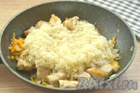 Рис промываем несколько раз водой, даём воде стечь. Рис выкладываем на сковороду к мясу и овощам.