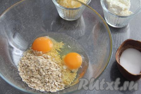 В миску всыпать овсяные хлопья и вбить сырые яйца.