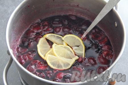 Затем снять варенье из черешни с огня и оставить на 2 часа при комнатной температуре. Половину лимона нарезать на тонкие дольки вместе с кожурой, удаляя косточки. Добавить дольки лимона в кастрюлю с черешней, перемешать.