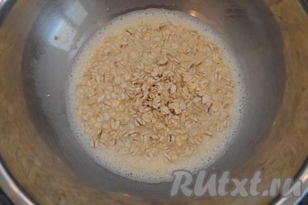 В яичную массу влить молоко, перемешать и добавить овсяные хлопья, снова перемешать и оставить на 7-10 минут (за это время овсяные хлопья быстрого приготовления набухнут).