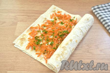 Начиная с узкой стороны, сворачиваем вместе два лаваша с начинкой в достаточно плотный рулет.