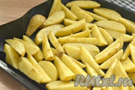 На противне, застеленном ковриком для выпечки (или пергаментной бумагой), раскладываем в один слой дольки картофеля. Ставим противень в духовку, прогретую до 180 градусов, и запекаем картошку по-деревенски минут 40-45 минут (дольки должны стать мягкими внутри, они будут легко прокалываться ножом).