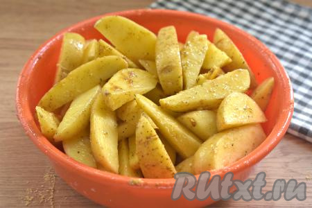 Очень хорошо перемешиваем дольки картофеля, покрывая их со всех сторон маслом и специями.