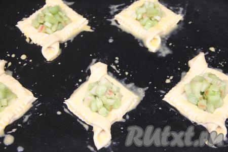 Яичный желток слегка взбить вилкой, а затем смазать им края теста. Поставить противень в разогретую духовку.&nbsp;