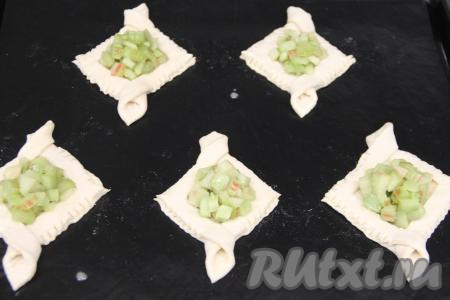 Прижать бортики вилкой. Таким образом сформировать все 8 заготовок слоек с бортиками и переложить их на противень, застеленный ковриком (или пергаментом) для выпечки. В середину заготовок, не заходя на бортики, равномерно распределить начинку из ревеня.