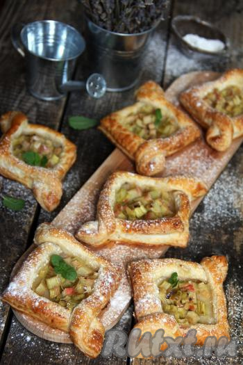 Готовые слойки переложить на тарелку, дать немного остыть, по желанию, слегка присыпать сахарной пудрой и подать к столу. Нежная кислинка ревеня очень украшает вкус этой выпечки.