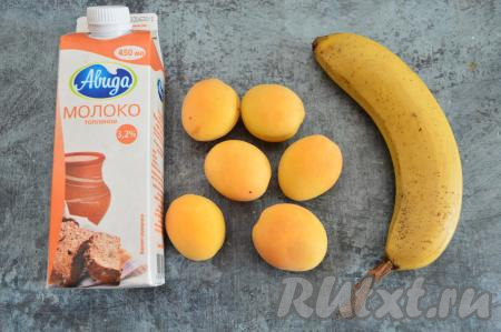 Подготовить продукты для приготовления смузи с абрикосами и бананом. Коровье молоко можно взять любой жирности, при желании его можно заменить на растительное молоко (например, на миндальное, кокосовое, соевое, овсяное). Банан лучше брать спелый или даже переспелый. Абрикосы тоже лучше использовать спелые.