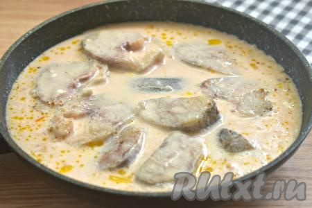 В отдельной ёмкости соединяем сметану, томатную пасту и тёплую кипячёную воду, тщательно перемешиваем получившийся томатно-сметанный соус и вливаем его в сковороду с минтаем.