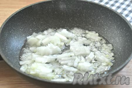 На сковороду вливаем растительное масло, прогреваем его на достаточно сильном огне, уменьшаем огонь до среднего, выкладываем мелко нарезанный лук, обжариваем его до прозрачности (в течение 2-3 минут), периодически перемешивая.
