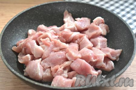 Наливаем на сковороду растительное масло, ставим на огонь. Когда масло разогреется, выкладываем нарезанную свинину и, периодически помешивая, жарим её на достаточно сильном огне 10 минут (до изменения цвета со всех сторон и лёгкого подрумянивания мяса).
