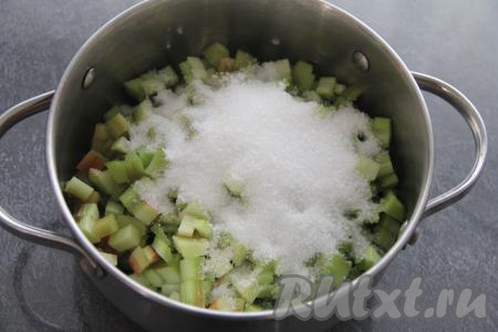 Нарезать стебли ревеня на мелкие кусочки. Выложить ревень в кастрюлю и всыпать сахар.