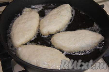В сковороду влить достаточно количество растительного масла, хорошо разогреть его на сильном огне, уменьшить огонь до среднего. Выложить пирожки в сковороду в один слой швом вниз.