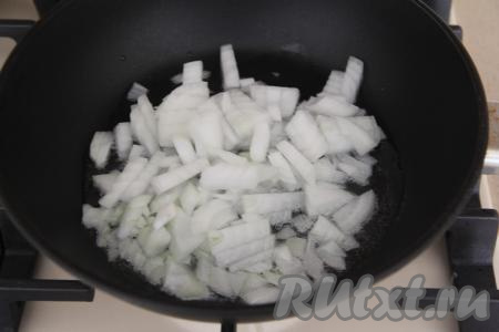 В сковороду влить растительное масло, хорошо его разогреть. В разогревшееся масло выложить лук, нарезанный достаточно мелко, обжаривать его минуты 3, помешивая, на среднем огне.