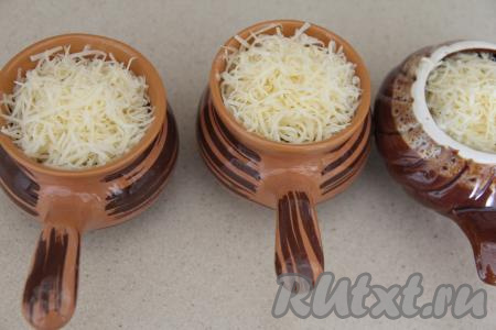 Поверх жульена из рыбы и грибов пышной шапочкой выложить сыр, натёртый на мелкой тёрке. Поставить кокотницы с жульеном в разогретую духовку и запекать 10 минут при температуре 180 градусов.