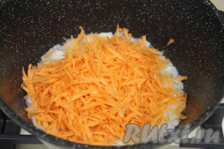 К обжаренному луку добавить натёртую на крупной тёрке морковку, перемешать овощи и обжаривать 3-4 минуты, не забывая иногда перемешивать.