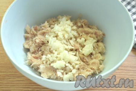 Очищенную луковицу мелко нарезаем (или измельчаем в измельчителе, или пропускаем через мясорубку) и выкладываем в миску с рыбным фаршем.