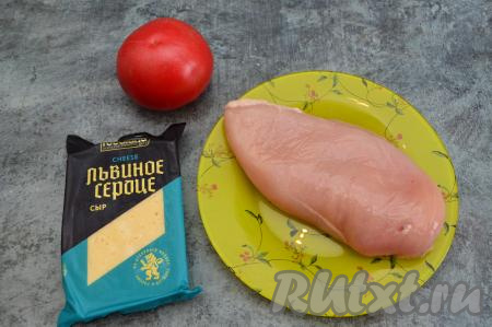 Подготовить продукты для приготовления куриного филе под помидорами и сыром в духовке. Помидор нужен плотный, чтобы его можно было нарезать на тонкие кружочки.