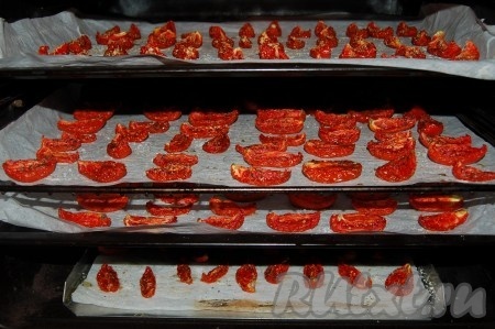 Можно посыпать любимыми специями или какой-нибудь сушеной травкой. Но тут важно не переборщить, иначе травка подгорит и помидоры будут иметь неприглядный вид. Отправить противни с готовыми помидорами в духовку. У кого духовка с конвекторным обдувом, могут разместить в духовке сразу несколько противней. Установить температуру в 70-90 градусов и сушить от 4 до 8 часов. Время готовности зависит от сорта помидор. Чем сочнее сорт, тем дольше они будут вялиться. Время от времени можно переворачивать помидоры.