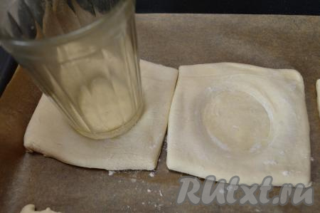 Дном гранёного стакана в центре каждого квадрата сделать углубление. Если стакан прилипает к поверхности теста, тогда припылите квадратики теста немножко мукой.