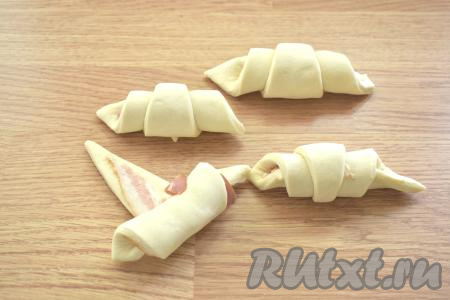 Сворачиваем треугольник с беконом в форме рулетика, начиная с основания треугольника.