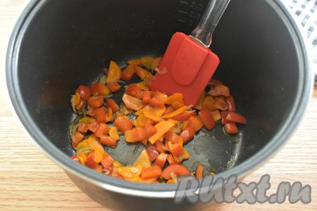 Вливаем в чашу мультиварки растительное масло и включаем режим "Жарка" на 10 минут. В разогревшееся масло выкладываем нарезанные лук, морковку и болгарский перец. Обжариваем овощи до окончания режима "Жарка", периодически перемешивая.