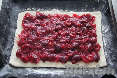 На этот пласт теста выложить остывшую начинку из черешни, отступив от краёв по 2-3 сантиметра.