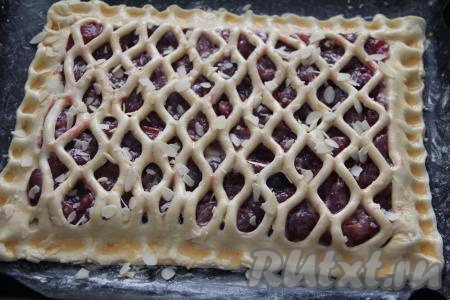 В отдельной ёмкости взбить вилкой яичный желток до однородности. Смазать верх пирога взбитым желтком. По желанию, можно посыпать пирог миндальными лепестками.