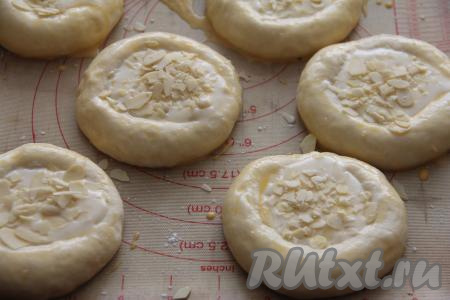 По желанию, присыпать миндальными лепестками. В небольшой ёмкости вилкой взбить яичный желток, получившейся смесью смазать бортики ватрушек.