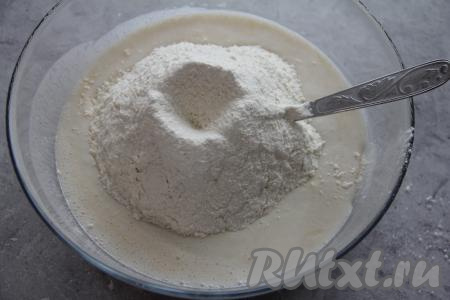Частями всыпая просеянную муку, перемешивать тесто сначала ложкой, а затем вымесить его в течение 5-7 минут руками.