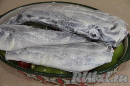 Подготовленную навагу посолить, смазать майонезом со всех сторон и выложить поверх овощей.