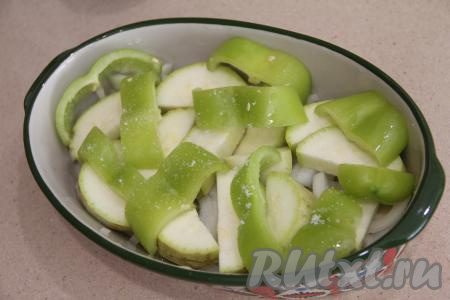 На кабачки выложить болгарский перец, нарезанный на широкие полоски, немного посолить.