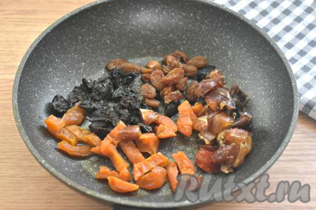 На сковороду вливаем растительное масло, выкладываем изюм и нарезанные курагу, чернослив и финики.