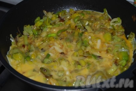 На сковороду с обжаренным луком-пореем влить взбитые яйца, уменьшить огонь до минимума.