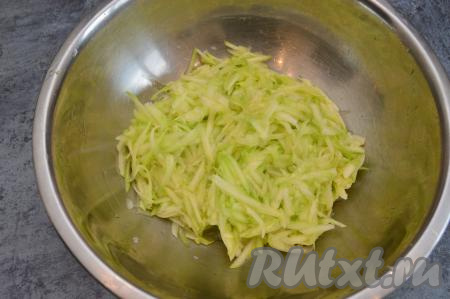 Кабачок очистить от кожуры. Если семечки крупные, их нужно будет удалить. Примерно 550 грамм подготовленного кабачка натереть на крупной тёрке в миску, посолить, тщательно перемешать и оставить минут на 15 минут. За это время кабачок выделит достаточно много сока.