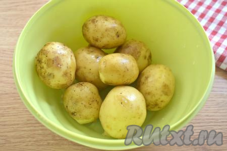 Молодую картошку тщательно промываем под проточной водой. Для того чтобы убрать с картошин грязь, можно использовать губку или щётку. Клубни очищать не нужно, запекать их будем в кожуре. Вымытый молодой картофель в кожуре перекладываем в миску.