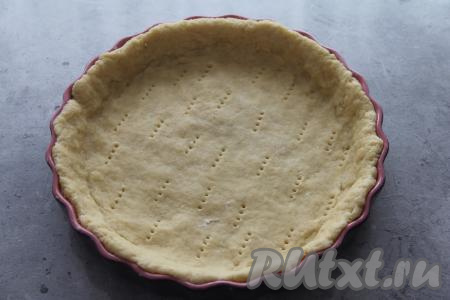 Пока песочное тесто охлаждается, можно подготовить начинку для пирога. По прошествии часа достать тесто из холодильника, выложить его в форму для выпечки (я взяла форму диаметром 26 сантиметров), сформировав невысокий бортик. Тесто на дне формы наколоть вилкой (благодаря проколам, тесто не будет вздуваться в процессе выпечки).