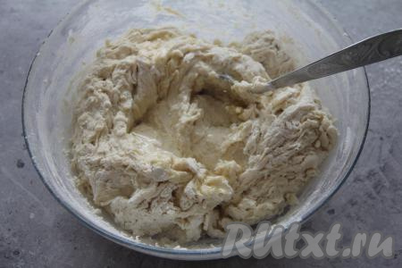 Всыпать часть просеянной муки и перемешать тесто ложкой. Затем влить растительное масло и, добавляя постепенно оставшуюся муку, замесить руками гладкое, нежное тесто.