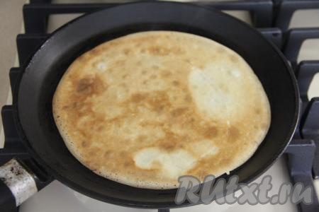 Сковороду (я взяла сковороду диаметром 20 сантиметров) очень хорошо разогреть, можно слегка смазать её маслом перед жаркой первого блина. Налить на раскалившуюся сковороду половник теста, равномерно распределить блинное тесто и жарить блинчик до подрумянивания с двух сторон на среднем огне, затем переложить на тарелку. Смазывая сковороду маслом только по мере необходимости и периодически перемешивая блинное тесто, пожарить все блины, складывая их стопочкой на тарелку.