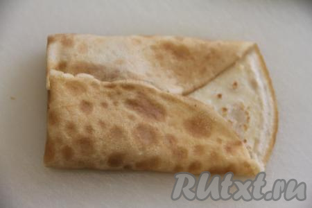 Свернуть блинчик с начинкой любым способом. Можно сделать конвертик, формируя его, как на фото. А можно сформировать в виде мешочка, подняв края блина над начинкой, а затем завязать мешочек.