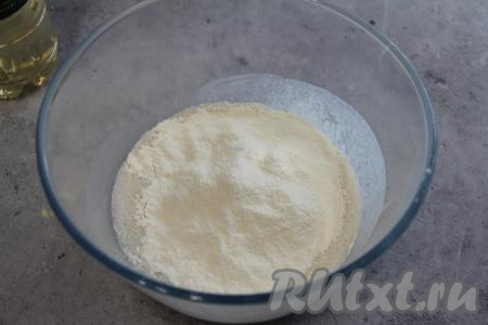 Перемешать, влить растительное масло и всыпать часть муки, перемешать ложкой.