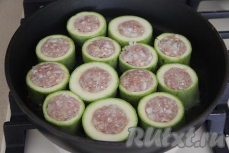 В сковороду влить растительное масло, поставить на огонь. После того как масло прогреется, выложить колечки кабачка с фаршем в сковороду.&nbsp;