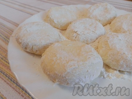 Влажными руками сформировать округлые заготовки сырников (я сформировала 7 штук). Каждую заготовку сырника обвалять в муке со всех сторон и выложить на припылённую мукой плоскую тарелку.